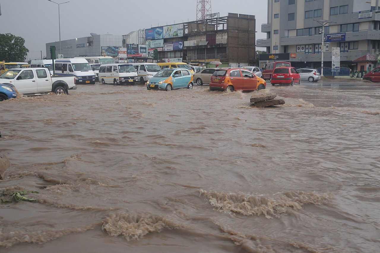 Flooded street in Accra following heavy rainfall with overcast skies