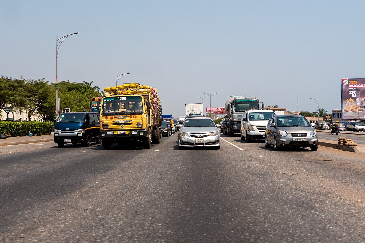 Vehicles navigating urban road infrastructure in Accra during daytime traffic management